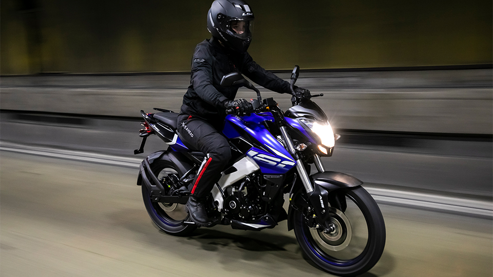piloto com roupa de motoqueiro em uma moto azul em alta velocidade