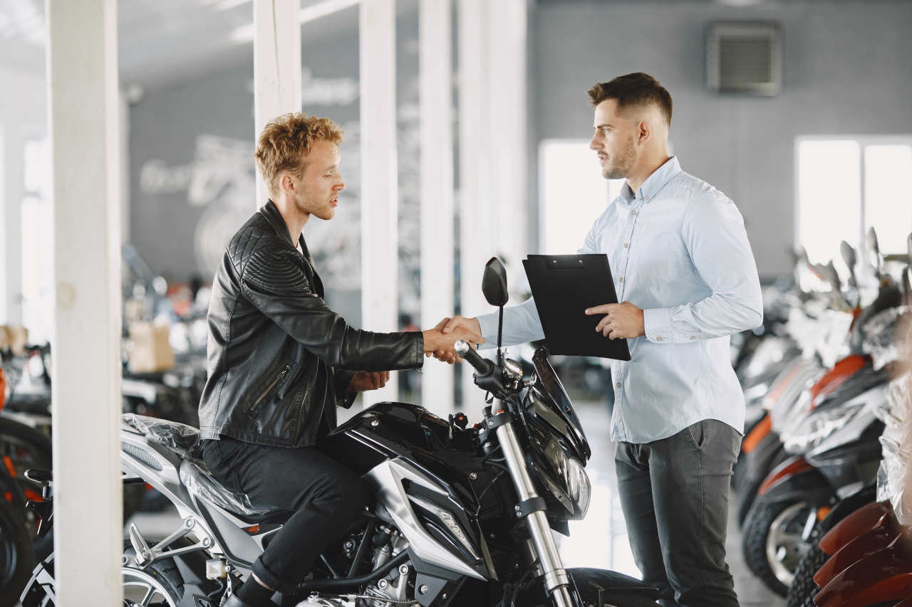 Homens negociando moto em concessionária