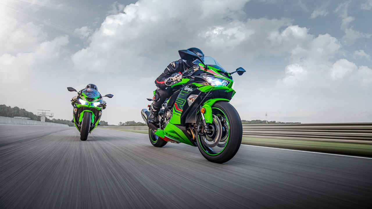 Duas pessoas pilotando motos verdes em pista