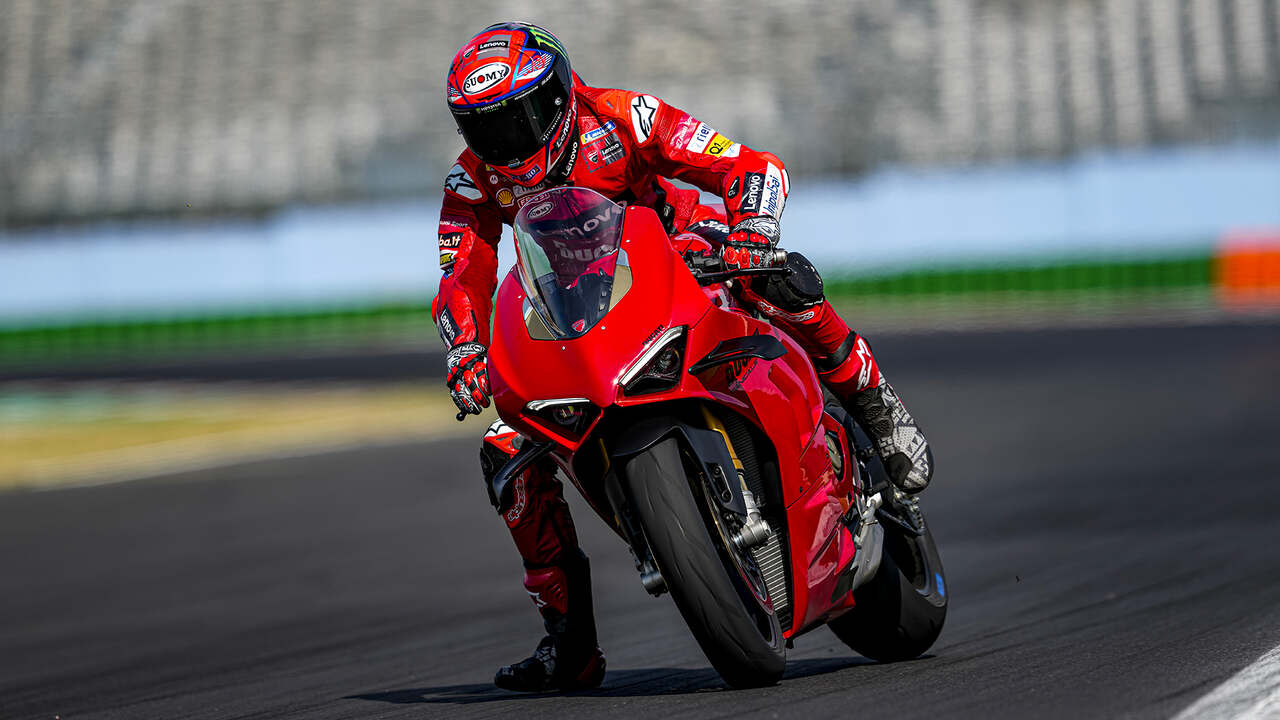 Piloto fazendo curva com pé no chão na Ducati Panigale V4 S 2024