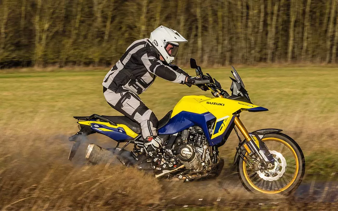 Homem pilotando uma Suziki V-Strom 800DE na estrada de chão