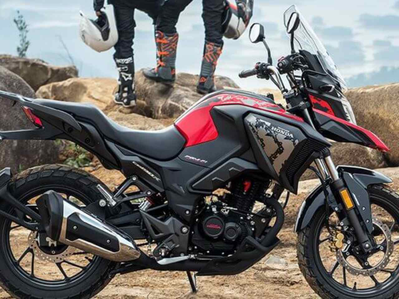 Honda CB190X estacionada em terreno arenoso