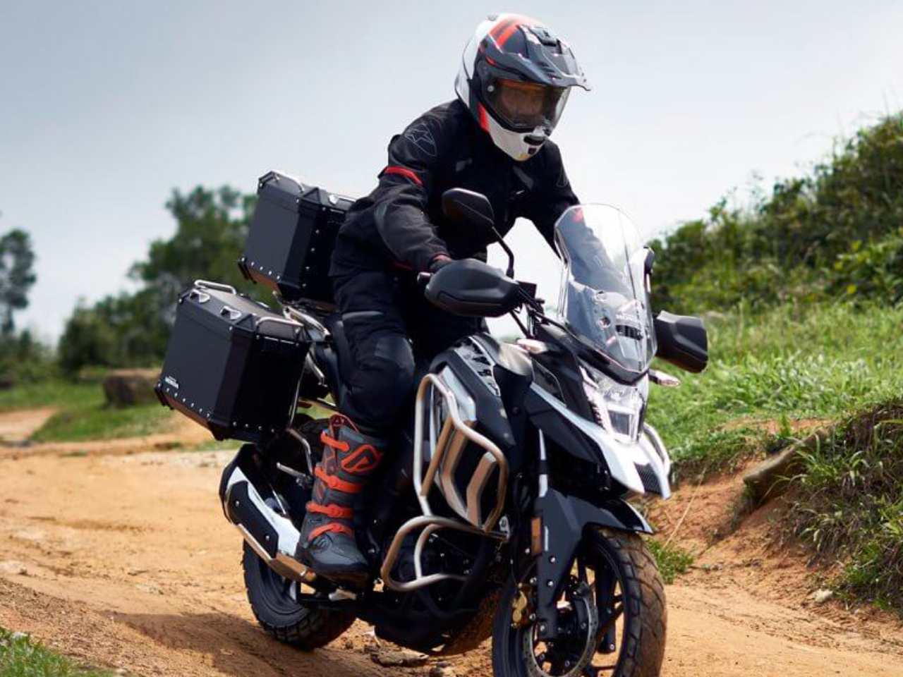 Homem pilotando Honda CB190X em terreno arenoso