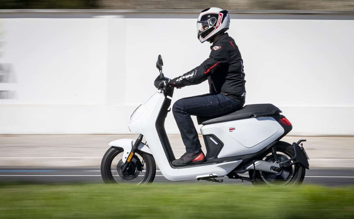 Motociclistas pilotando uma Niu MQi GT branca