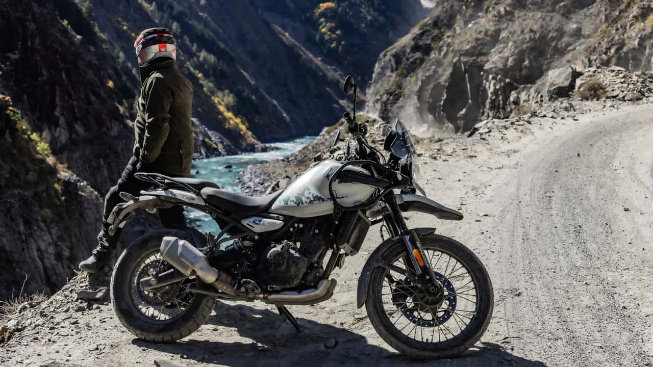 Homem parado ao lado de uma motocicleta Royal Enfield Himalayan 450